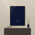 Midnight birth chart poster in a black wood frame above a sideboard